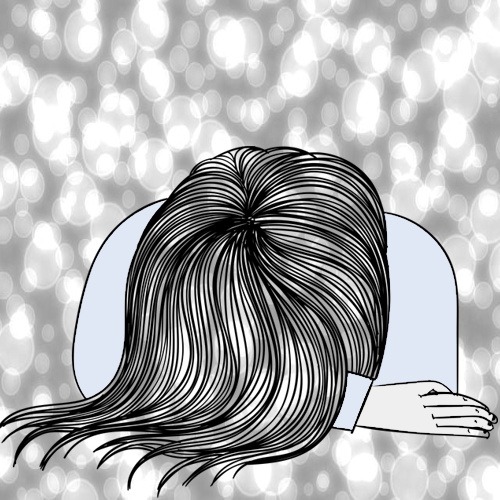 Femme assise à une table, tête posée sur les bras, visage caché, posture fatiguée et abattue, illustrant la fatigue liée à la douleur chronique.