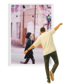 Homme de dos en léger déséquilibre regardant par une fenêtre une jeune femme en mouvement, qui avance sereine et pleine d'énergie dans une rue au printemps